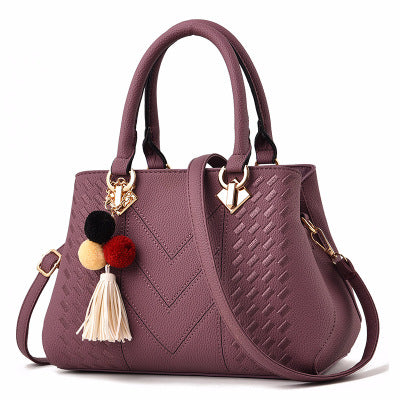 Embossed handbag with pompom charm