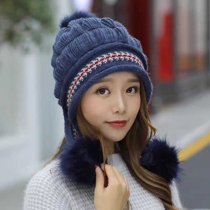 Woman in an ear flap beanie with pompom